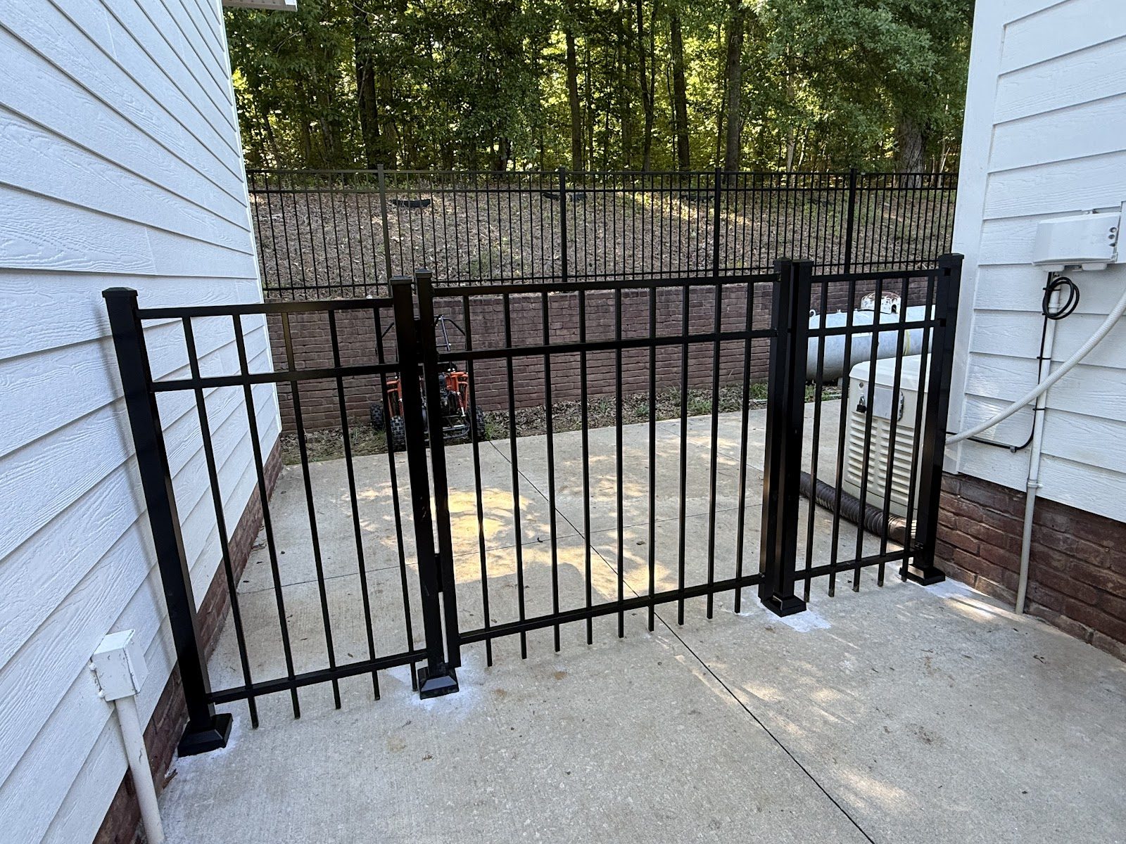 Black aluminum fence and gate between two houses