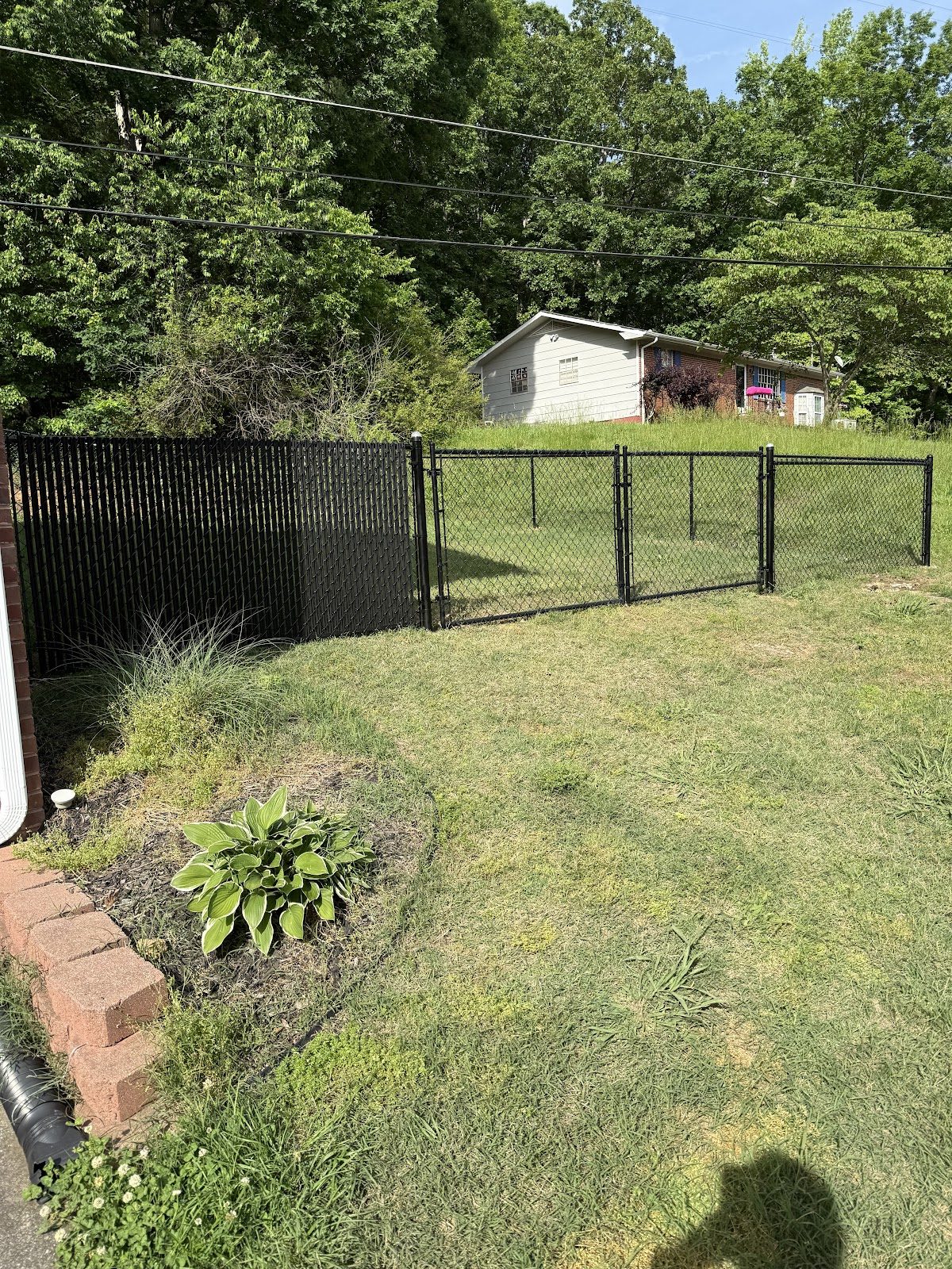 Black fence and gates beside garden landscaping
